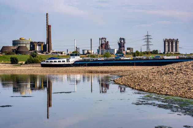 Extremely low water levels—here at the Thyssenkrupp Steel plant in Duisburg-Marxloh—have caused sandbars to form due to the low water level in the Rhine; cargo ships can only sail with reduced cargo; the TKS steel mill has cut back production because not enough raw