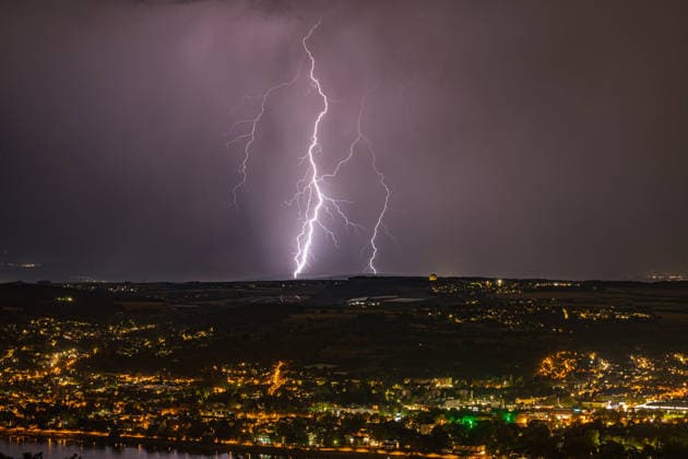 Lightning strike over the Rhine Valley near Bad Godesberg and Wachtberg; view from Petersberg in the Siebengebirge range looking west; a bolt of lightning strikes near a thunderstorm front; in the foreground, the Rhine and the towns of Bonn, Mehlem, Bad Godesberg, and Wachtberg; clearly visible is the radome of the Fraunhofer Ins Copyright: xMarcxJohnx