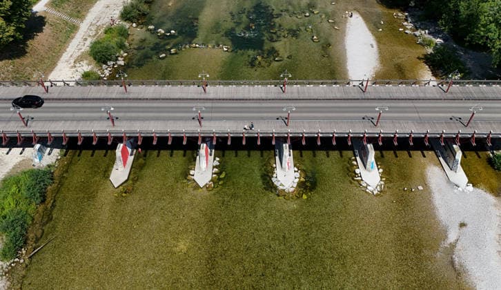 A summer day in Munich, the state capital. Here is a view of the Thalkirchner Bridge, a road bridge over the Isar River and the parallel Isar Werkkanal, which will be closed for two years starting in 2027 due to renovation, maintenance, traffic congestion, detours, neighborhoods, the zoo, and frustrated residents