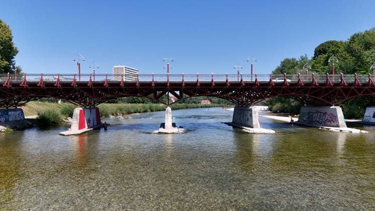 A summer day in Munich, the state capital. Here is a view of the Thalkirchner Bridge, a road bridge over the Isar River and the parallel Isar Werkkanal, which will be closed for two years starting in 2027 due to renovation, maintenance, traffic congestion, detours, neighborhoods, the zoo, and frustrated residents