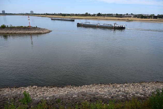 Historically low water levels on the Rhine; the Düsseldorf Water Police report that the Rhine’s water level in Düsseldorf has reached 23 cm—the lowest ever recorded there. Low water level, rocky riverbank, a tall red bank marker; in the background, two cargo ships pass each other. Düsseldorf, August 4, 2026