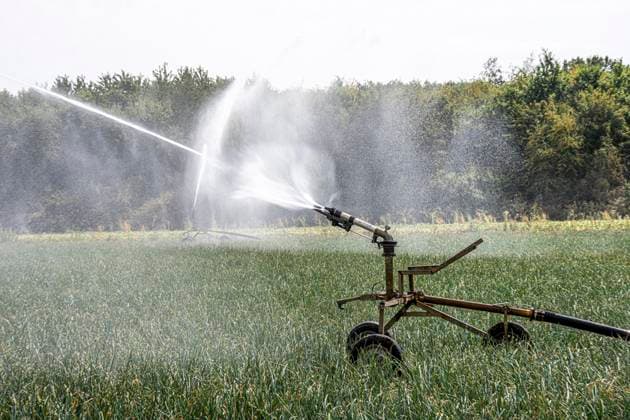 Artificial irrigation of a field using a sprinkler system; a prolonged dry spell in the summer makes this necessary to ensure a good harvest, near Niederkrüchten, North Rhine-Westphalia, Germany. Artificial irrigation