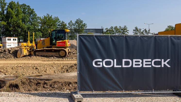 Construction Begins on Cargo Center 3 at Nuremberg Airport, Nuremberg, August 4, 2026: At the Cargo Center construction site, a bulldozer stands on a pile of dirt; in the foreground, a construction fence bearing the word Goldbeck is visible. Earthwork marks the start of construction on a new cargo terminal at Nuremberg Airport, Bavaria, Germany 20260804-286A4194-M4000