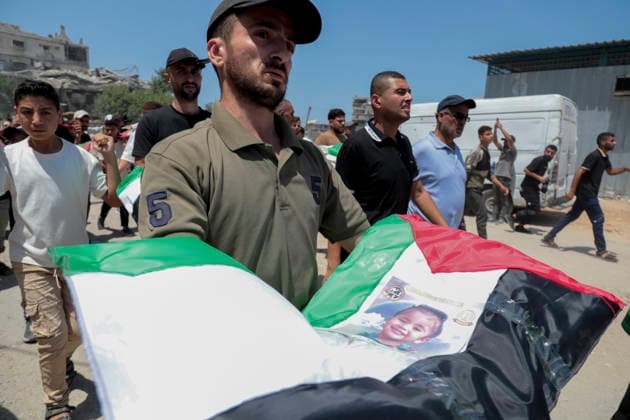 Gaza City Mass Funeral August 3 2026 Mourners carry bodies wrapped in Palestinian flags and adorned with photographs during a mass funeral procession in the Al-Sabra neighborhood of Gaza City, Gaza Strip, on August 4, 2026. The remains of 112 members of the Abu Sharia and Al-Hasayneh families were recovered from the rubble of their home following an Israeli strike. Relatives stated the attack claimed the lives of more than 300 people. The bodies were buried at Al-Maamadani Cemetery as military operations continue across the territory. Gaza Gaza Strip Palestinian Territories Copyright: xEyadxAzamx