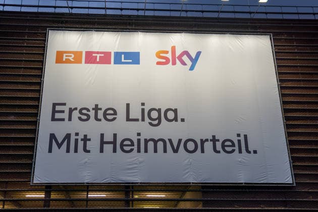 Large-scale advertising banner from RTL and Sky featuring the slogan First Division with Home-Field Advantage in Cologne —a symbolic image representing TV broadcast rights, the Bundesliga, sports broadcasting, and soccer media Copyright: xSvenxHeidmannx