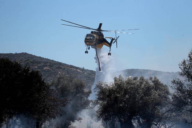 August 5, 2026, Koropi, Greece: Firefighters battle a wildfire in the Koropi area, southeast of Athens, as helicopters carry out repeated water drops to contain the flames. Ground crews worked alongside aerial firefighting units to prevent the fire from spreading amid dry conditions and strong winds. Koropi Greece  - ZUMAv62_ 20260805_zaf_v62_052 Copyright: xAristidisxVafeiadakisx