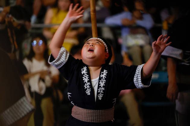 August 5, 2026, Akita, Japan: A participant balances a bamboo pole adorned with paper lanterns (kanto) on his forehead during the Akita Kanto Festival in Akita City. The annual event is one of the Tohoku region s three great festivals, where street performers skillfully balance over 270 towering bamboo poles (with the largest measuring 12 meters and weighing 50 kilograms) adorned with up to 46 candle-lit paper lanterns on their hands, shoulders, and foreheads to the rhythmic chant of dokkoisho. The festival runs from August 3 to 6. Akita Japan  - ZUMAm191 20260805_aap_m191_017 Copyright: xRodrigoxReyesxMarinx