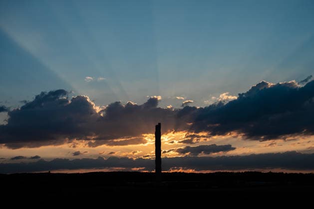 The sun sets behind the TK Elevator test tower in Rottweil. The test tower can be seen as a silhouette against the evening sky. Rottweil, Baden-Württemberg, Germany