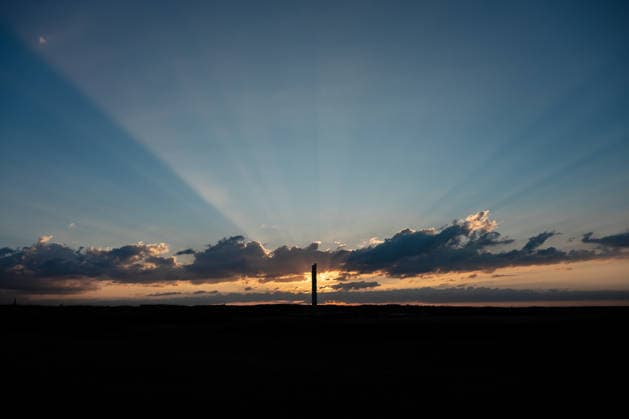 The sun sets behind the TK Elevator test tower in Rottweil. The test tower can be seen as a silhouette against the evening sky. Rottweil, Baden-Württemberg, Germany