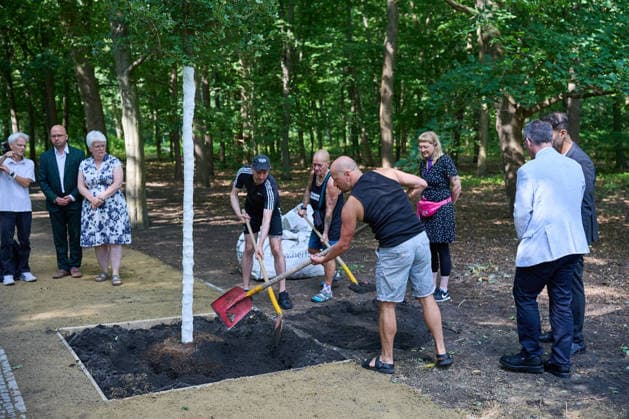 Nach der Attacke auf den Berliner Christopher Street Day (CSD) wird am Donnerstag (06.08.2026) im Tiergarten ein neuer Baum am Anschlagsort gepflanzt (im Foto: Mitglieder der LGBTQI+ und Queer-Community werfen Erde in das Pflanzloch des neuen Baums). Ein franzoesischer Ahorn ersetzt den Baum, der infolge des Anschlags gefaellt wurde. Der Baum soll ein schuetzendes Metallgitter erhalten, an dem Karten, Fotos, Blumen und persoenliche Botschaften angebracht werden koennen. Neben dem Baum stellt das Bezirksamt eine Bank in den Farben des Regenbogens auf. Diese soll zum Innehalten, Verweilen und zur stillen Anteilnahme einladen und Solidaritaet mit der queeren Community zum Ausdruck bringen. (Siehe epd-Meldung vom 06.08.2026) EDITORIAL USE ONLY Copyright: epd-bild ChristianxDitsch D26D0806CSDAnschlagGedenkort110342