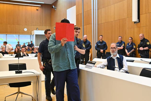 The defendant is escorted into the courtroom by court officers. The verdict in the criminal case against Farhad Noori for murder, among other charges, related to the Seidlstrasse incident will be handed down on August 6, 2026, at the Munich Higher Regional Court.