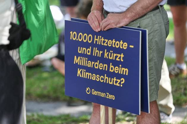 Berlin, Germany, August 6, 2026 Federal Chancellery Climate Alliance Calls for Heat Summit: Sign Reading 10,000 Heat-Related Deaths, and You’re Cutting Billions from Climate Protection Copyright: xdtsxNachrichtenagenturx dts_129452