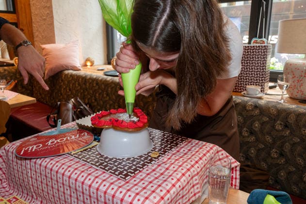 Munich, press conference for the 2027 Wirtshauswiesn at Spoeckmeier; a staff member from Cafe Luitpold decorates gingerbread hearts with the desired inscription