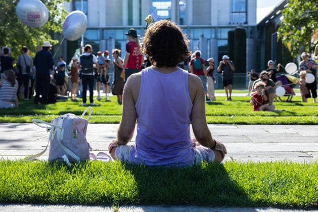 Fridays for Future Berlin Heat Protest Germany, Berlin, August 6, 2026: A man in a yoga pose in front of the demonstration. In front of the Chancellery, climate activists are protesting under the slogan Climate Crisis Escalates, Chancellor Remains Silent. They are demanding stronger climate protection measures, rapid political action to combat