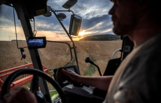 Nuremberg: Combine Harvester at Dusk A farmer is harvesting a large rapeseed field near Burghaslach in Franconia, Bavaria, with his Claas Tucano combine harvester. Sometimes, from the driver’s cab, he catches a glimpse of romantic sunsets. During hot summers, there are often only a few days available for the harvest, which must be us