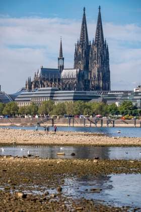 Low water levels in the Rhine near Cologne, View looking south from the right bank of the Rhine at Rheinpark; the city center with the cathedral; inland waterway shipping is severely restricted, with only a few ships operating, and those carrying greatly reduced loads; on the day this photo was taken, the Rhine water level in Cologne was the lowest ever recorded to date, at 60 cm, No