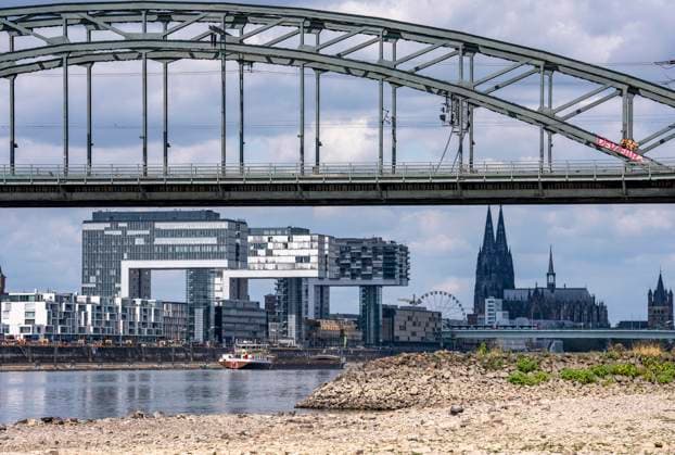 Low water levels on the Rhine near Cologne; view from the right bank of the Rhine across the Poller Wiesen, looking north toward the Südbrücke, the downtown skyline with the cathedral; inland waterway shipping is severely restricted, with only a few ships operating—and those with greatly reduced cargo; on the day this photo was taken, the Rhine wa