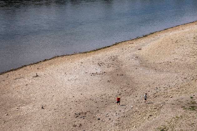 Low water levels on the Rhine near Cologne; view from the right bank of the Rhine across the Poller Wiesen, looking north; Walkers on the sandbar; inland waterway traffic is severely restricted, with only a few ships sailing—and those with greatly reduced cargo. On the day this photo was taken, the Rhine water level in Cologne had reached its lowest recorded leve