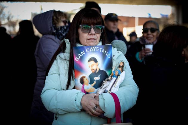 San Cayetano in Buenos Aires, Argentina - 7 Aug 2026 A devotee holds a poster with the image of San Cayetano during the feast of San Cayetano. Small prayer cards bearing the saint s image and stalks of wheat—representing bread—are a common sight every August 7th, the feast day of San Cayetano, the patron saint of bread and work. Buenos Aires Argentina Copyright: xRobertoxTuerox xSOPAxImagesx ROBTUERO_20260807283