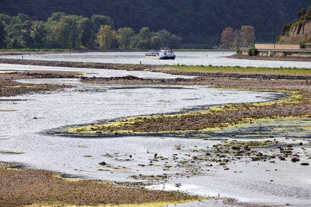 August 7, 2026, Bingen, Germany: Low water levels on the Rhine as seen from Bingen. A cargo ship is slowly navigating through the remaining channel.