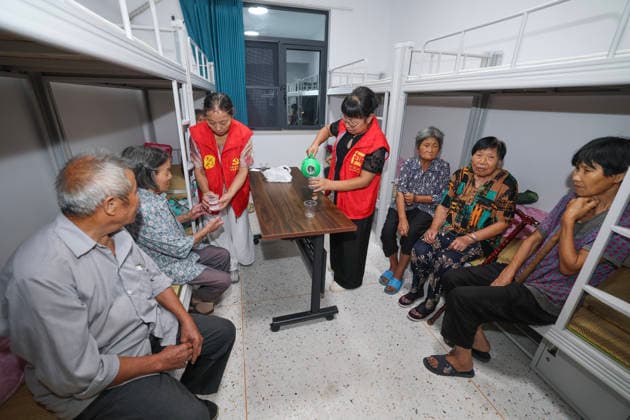 (260808) -- WUYI, Aug. 8, 2026 -- Volunteers pour drinking water for villagers at a temporary shelter in Datian Township, Wuyi County, Jinhua City, east China s Zhejiang Province, Aug. 8, 2026. The shelter has received 92 villagers, offering health check, meal delivery and other daily service. Coastal areas of eastern China were bracing for strong winds and torrential rain as Typhoon Dolphin approached, prompting authorities to recall fishing boats, suspend ferry services and prepare for evacuations. China s meteorological authority on Saturday upgraded its emergency response for Dolphin to Level III and raised the typhoon warning from yellow to orange. ) CHINA-ZHEJIANG-TYPHOON DOLPHIN-PREVENTION (CN) XuxYu
