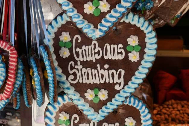 After Oktoberfest, the Gäubodenvolksfest in Straubing is the most famous folk festival in Bavaria. The amusement park features around 130 rides. Fairgoers at the fairground. Photo: Gingerbread heart—Greetings from Straubing