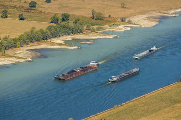 Aerial view, historic low water level on the Rhine, Ork, Voerde, Ruhr region, North Rhine-Westphalia, Germany, inland cargo ships, some of which are loaded. ATTENTION: MINIMUM FEE: 60 EUR