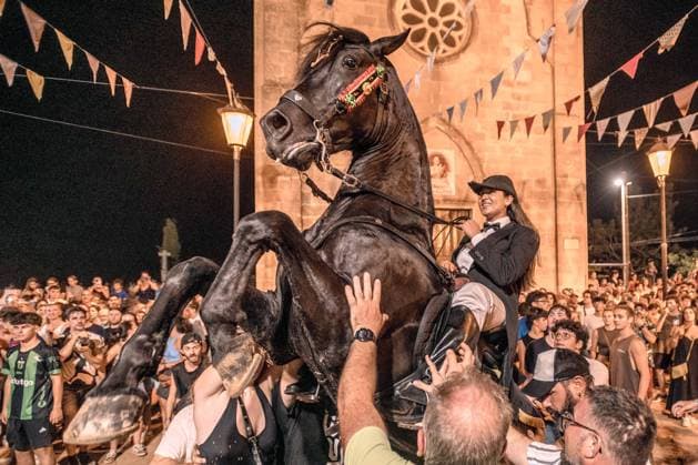 August 8, 2026, Llucmacanes, Menorca Balearic Islands, Spain: A caixer, or horse rider, rears his horse amid a cheering crowd during the traditional Jaleo at the Sant Gaieta Festival in Llucmacanes Llucmacanes Spain - ZUMAo105 20260808_fap_o105_027 Copyright: xMatthiasxOesterlex