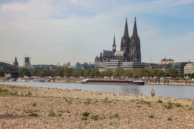 Summer in the Rhineland: View of the Rhine near Cologne, Deutz. The Rhine in Cologne is at low water levels due to persistent drought. Cologne Cathedral is visible in the background. A ship is passing by. Summer in the Rhineland on August 9, 2026, in Cologne, Germany