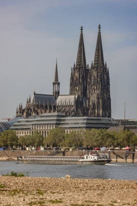Summer in the Rhineland: View of the Rhine near Cologne, Deutz. The Rhine in Cologne is at low water levels due to persistent drought. Cologne Cathedral is visible in the background. A ship is passing by. Summer in the Rhineland on August 9, 2026, in Cologne, Germany