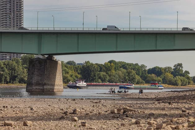 Summer in the Rhineland: View of the Rhine near Cologne, Deutz. The Rhine in Cologne is at low water levels due to persistent drought. Two ships are passing by. In the center of the picture is the Zoobrücke bridge. Summer in the Rhineland on August 9, 2026, in Cologne, Germany