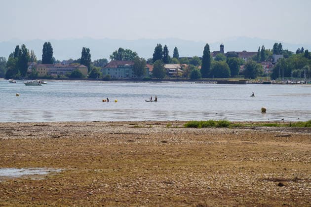 Lake Constance near Bottighofen, Canton of Thurgau, Switzerland; Water levels have receded significantly, exposing large areas of gravel and shoreline; Total, low water, Lake Constance shoreline, gravel bank, shallow water zone, drought, climate change, heat, extreme weather, water scarcity, environment, nature, swimmers, stand-up paddleboard Copyright: xJOERANxSTEINSIEKx