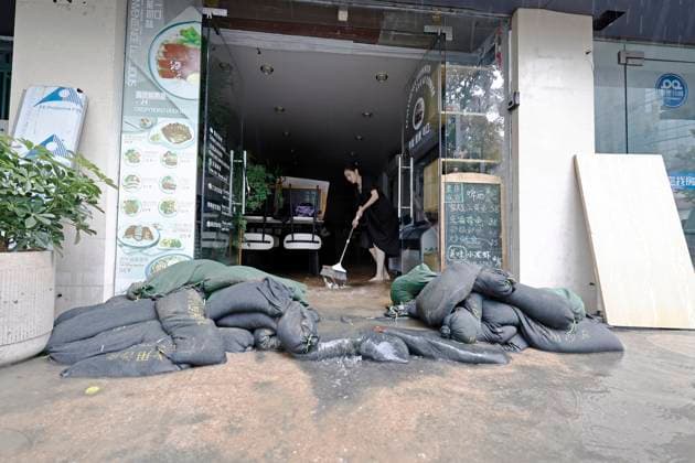 SHANGHAI, CHINA - AUGUST 09: Staff members sweep up accumulated water inside a shop on August 9, 2026 in Shanghai, China. The Shanghai Meteorological Observatory upgraded the rainstorm warning signal for the central urban area from orange to red at 10:30 a.m. due to the impact of Typhoon Dolphin.  Copyright: xChinaxNewsxServicex 111658975273