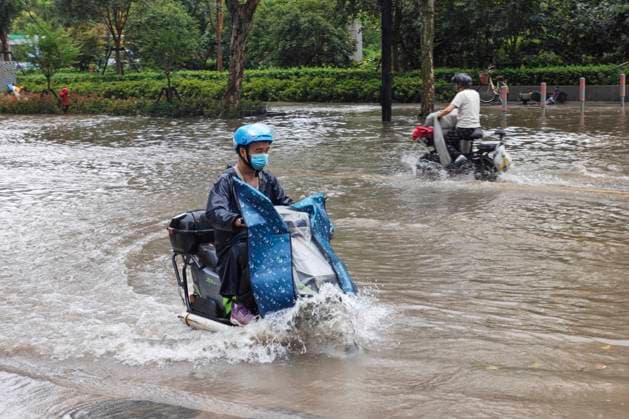 SHANGHAI, CHINA - AUGUST 09: A delivery rider wades through deep water on Lingling Road as Typhoon Dolphin brings heavy rainfall to the city on August 9, 2026 in Shanghai, China. The typhoon has caused significant flooding and strong winds across the region.  Copyright: xVCGx 111659005853