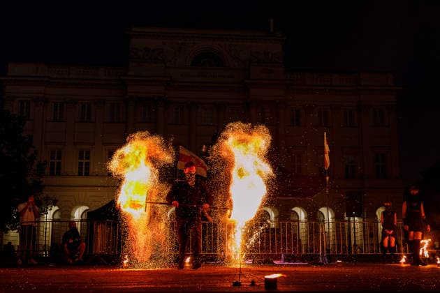 August 9, 2026, Warsaw, Poland: Participants light a flare near the Nicolaus Copernicus Monument during an evening rally marking the sixth anniversary of the August 2020 presidential election in Belarus. An evening gathering marking the sixth anniversary of the August 2020 presidential election in Belarus was held near the Nicolaus Copernicus Monument in central Warsaw, bringing together leaders of Belarusian democratic forces, public figures and activists, as well as several hundred participants. Warsaw Poland - ZUMAs197 20260809_aaa_s197_116 Copyright: xVolhaxShukailax