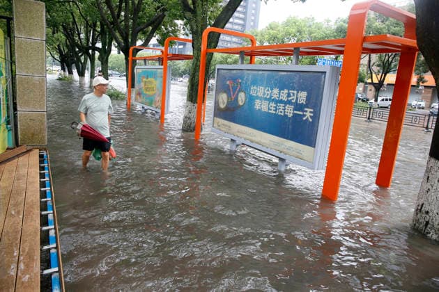 WENLING, CHINA - AUGUST 10: A resident walks through flooded street on August 10, 2026 in Wenling, Zhejiang Province of China. Heavy rainfall brought by Typhoon Dolphin caused severe waterlogging on roads and affecting residents travel. Typhoon Dolphin, the 13th typhoon of the year, made landfall at Yuhuan of Taizhou City, east China s Zhejiang Province, at around 5:30 p.m. on August 9.  Copyright: xVCGx 111659097428