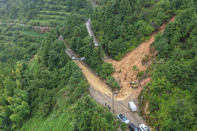 WENZHOU, CHINA - AUGUST 09: Excavators clear landslide debris to reopen a blocked village road on August 9, 2026 in Wenzhou, Zhejiang Province of China. Strong winds up to level 15 (46.2 to 50.9 meters per second) have ripped through Yueqing City in east China s Zhejiang Province since Typhoon Dolphin made landfall in the region on Sunday, with hundreds of toppled trees and broken branches blocking roads across the city.  Copyright: xVCGx 111659124824