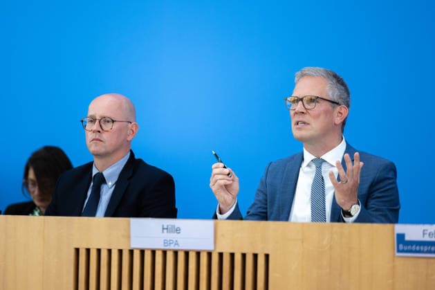 German Government Press Conference, Berlin, August 10, 2026: Martin Giese, Spokesperson for the Federal Foreign Office (AA), alongside Sebastian Hille, Deputy Spokesperson for the Federal Government (BPA), addressing the press in the Federal Press Conference Hall