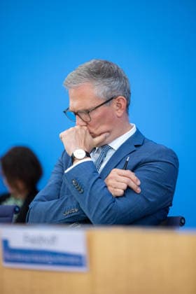 German Government Press Conference, Berlin, August 10, 2026: Sebastian Hille, looking pensive, Deputy Spokesperson for the Federal Government, faces the press in the Federal Press Conference Hall