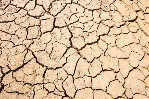 Drought and Water Shortage: Cracked and dry soil as a symbolic image of water shortage, drought, and heat. PHOTOMONTAGE FOR EDITORIAL USE ONLY