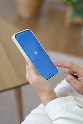 Handy mit neuem ?X?-Logo für Twitter auf blauem Hintergrund mit weißem Vogel; Elon Musk verspricht, das Vogel-Logo abzuschaffen mobile phone with new logo X for twitter on blue background with white bird, Elon Musk vows to ditch bird logo. (License=RM) Copyright: xZoonar.com WICHAYADAxSUWANNACHUNx 25405299