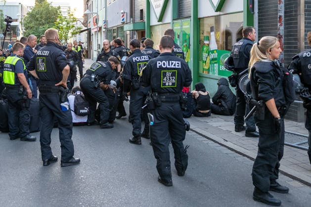 Police operation during Monday demonstration by Team Menschenrechte and counter-protests, Nuremberg, 10 087 2026 Police officers break up a blockade on Klaragasse. Several people are sitting on the street and the sidewalk, while numerous officers in riot gear bring the situation under control. Nuremberg, Bavaria, Germany 20260810-6V2A0854-M4000