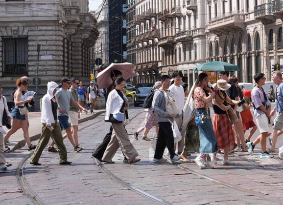 IPA87397532 - Milan, August 11, 2026: It’s hot in Milan. The heat wave continues, and tourists are shielding themselves from the sun with clothing, umbrellas, and hats, and are cooling off or drinking water at the fountain in Piazza Scala.  Copyright: xDuilioxPiaggesix xDuilioxPiaggesix 87397532