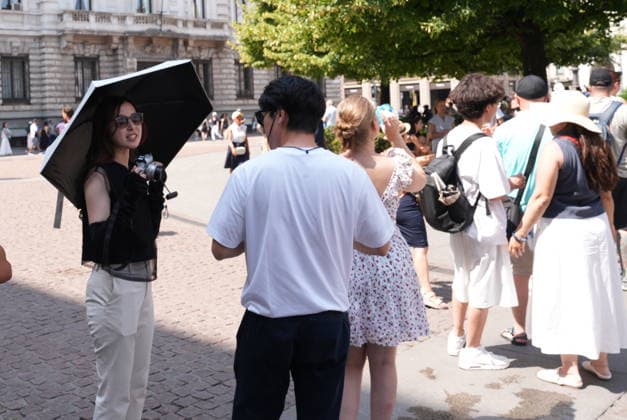 IPA87397512 - Milan, August 11, 2026: It’s hot in Milan. The heat wave continues, and tourists are shielding themselves from the sun with clothing, umbrellas, and hats, and are cooling off or drinking water at the fountain in Piazza Scala.  Copyright: xDuilioxPiaggesix xDuilioxPiaggesix 87397512