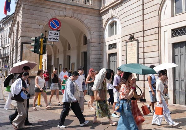IPA87397524 - Milan, August 11, 2026: It’s hot in Milan. The heat wave continues, and tourists are shielding themselves from the sun with clothing, umbrellas, and hats, and are cooling off or drinking water at the fountain in Piazza Scala.  Copyright: xDuilioxPiaggesix xDuilioxPiaggesix 87397524