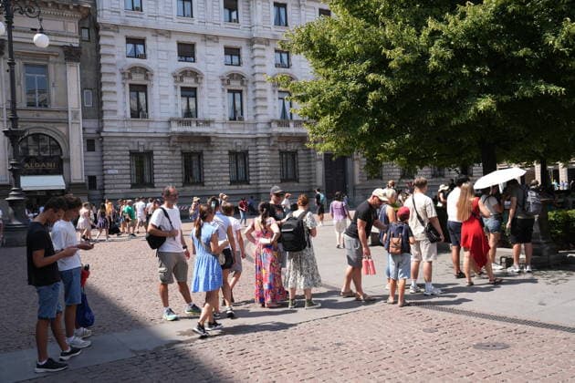 IPA87397531 - Milan, August 11, 2026: It’s hot in Milan. The heat wave continues, and tourists are shielding themselves from the sun with clothing, umbrellas, and hats, and are cooling off or drinking water at the fountain in Piazza Scala.  Copyright: xDuilioxPiaggesix xDuilioxPiaggesix 87397531