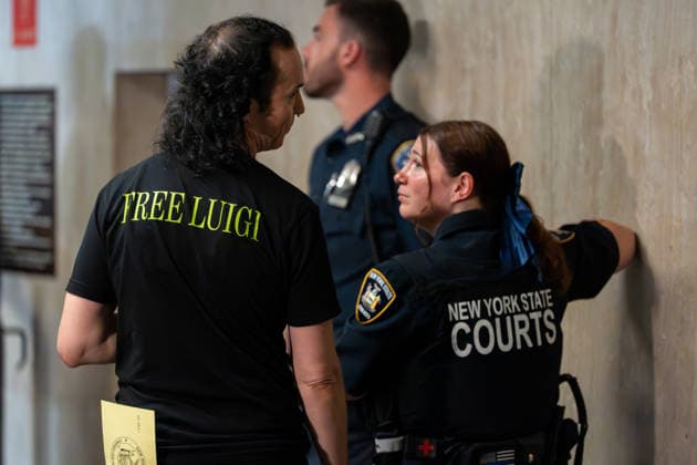 A Luigi supporter speaks to a court officer at Manhattan Criminal Court, in New York City as Luigi Mangione, accused of killing Brian Thompson, the CEO of UnitedHealthcare, attends a pre-trial appearance at Manhattan Criminal Court, in New York City, on Tuesday, August 11, 2026. Pool  NYX20260811214 DAVIDxDEExDELGADO