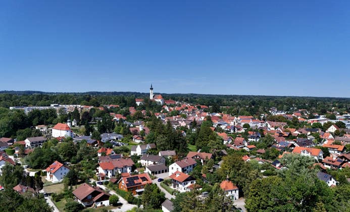 A summer day in Dießen on Lake Ammersee, Landsberg am Lech District. Here is a view of the town from above: a cityscape, townscape, skyline, and view of the houses; in the center of the image is the monastery, the Cathedral of the Assumption of Mary.