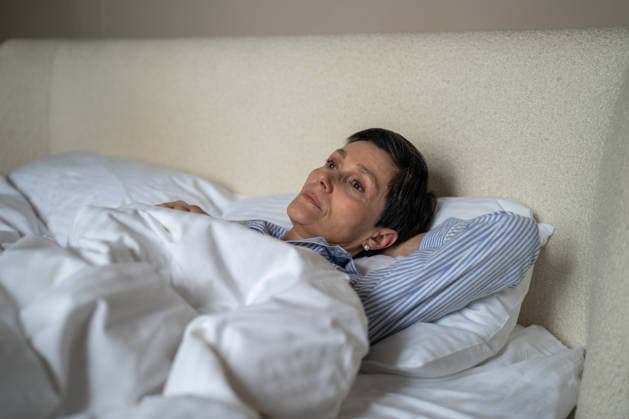 Eine unglückliche, nachdenkliche ältere Frau, die morgens zu Hause im Bett liegt und einen verlorenen, erschöpften Gesichtsausdruck hat. Unhappy thoughtful senior woman lying in bed in morning at home with lost exhausted expression, elderly female in bedroom showing loneliness and depression at older age, life after divorce. Melancholy (License=RF) ,model released, Symbolfoto Copyright: xZoonar.com DmitriixMarchenkox 25423469 ,model released, Symbolfoto ,property released