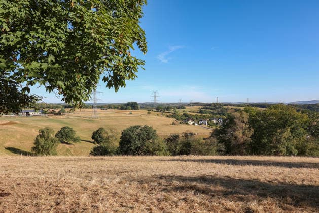 Summer in the Siegerland: Another sunny morning. The forests around Siegen and Oberschelden are green. Due to the lack of rain, some meadows are yellow. Summer on August 12, 2026, in Siegen, Germany